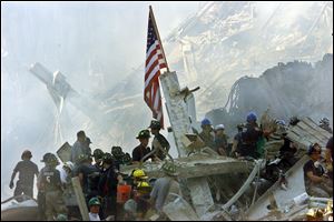 An American flag flies over the rubble of the collapsed World Trade Center buildings in New York in this Sept. 13, 2001, file photo.