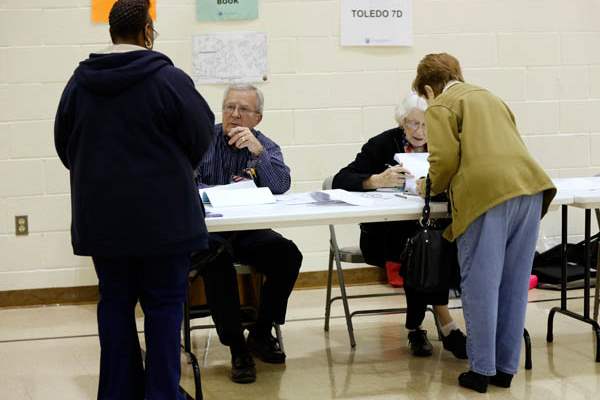 Poll-workers-John-Dougherty-left-and-Joanne-Moore-check-in-voters