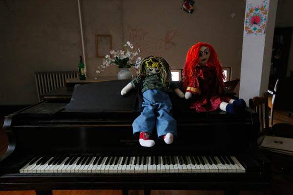 Two-handmade-dolls-sit-on-the-piano-in-one-of-the-c