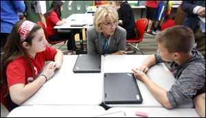 U.S. Education Secretary Betsy DeVos and fifth graders Kierden Yoh, left, and Gage Stemen talk about the class lecture about the Great Depression at Van Wert Elementary School. 