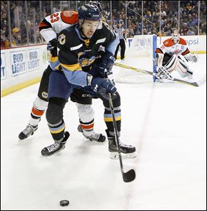 Toledo Walleye player Zach Nastasiuk is pressured by a Fort Wayne player. Nastasiuk recently played his 100th game in Toledo.