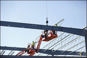 Workers with Henry Gurtzweiler Inc., install roof trusses for the new Cutting Edge Countertops factory in Perrysburg.