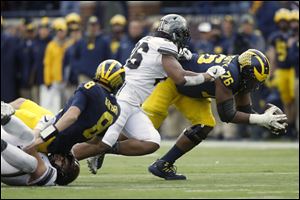 Michigan's Juwann Bushell-Beatty (76) recovers a fumble from teammate John O'Korn during last year's game vs. Ohio State. Keeping the QB clean and opening holes in the run game will be key for the Bushell-Beatty and the UM offensive line in 2018.
