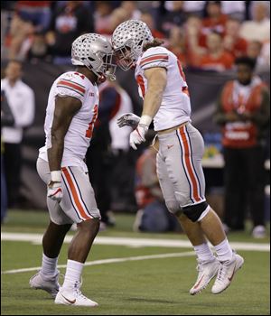 Ohio State's Nick Bosa, right, and Jalyn Holmes celebrate after Wisconsin quarterback Alex Hornibrook was sacked during the second half of the Big Ten championship game. The Big Ten champion Buckeyes were shut out of the college football playoffs, and will settle for a Cotton Bowl date against Southern California.