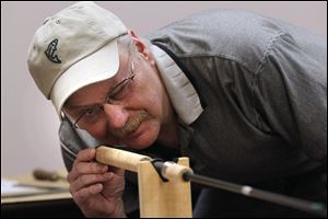 Denny McLean checks to make certain the line guides are in the proper alignment during a rod building class at Netcraft in Maumee. 