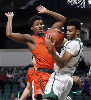 BGSU's Justin Turner defends while Eastern Michigan's Elijah Minnie grabs a rebound. Turner has helped improve the Falcons defense as BG started the season 11-5.