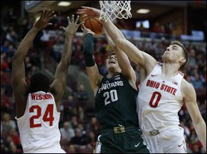 Michigan State guard Matt McQuaid, center, goes up to shoot between Ohio State forward Andre Wesson, left, and center Micah Potter on Saturday in Columbus.