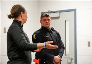 Toledo Police officer Amanda Coressel, left, makes a suggestion to Cadet Rutherford after the scenario is complete. She played the role of the angry wife in the domestic violence scenario.