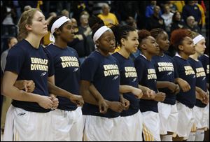 Toledo, wearing EMBRACE DIVERSITY shirts, link arms before their basketball game against Akron at the University of Toledo's Savage Arena in Toledo, Ohio.