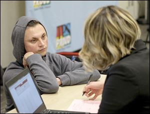 Devon Rodriguez, 19, checks in with Carrie Kolodziejczyk, Director of Student Information and Reporting for TPS, during an information night for the parents of ECOT students who were displaced after the online charter school abruptly closed midway through the year.