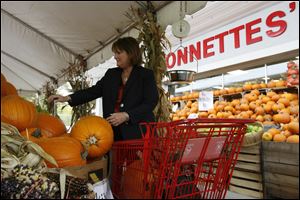 Kathy Vasquez, from Toledo, looks for several pumpkins to buy at Monnettes' Market.