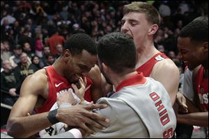 Ohio State forward Keita Bates-Diop, left, celebrates with teammates Andrew Dakich, right, and Joey Lane after defeating Purdue 64-63.