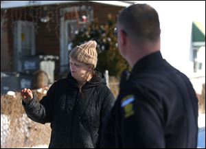 Tammy Buchanan speaks to Toledo police officers and Toledo Area Humane Society officers during a follow-up on an animal welfare complaint on the 3000 block of Chase Street in Toledo on Monday, February 12, 2018. 