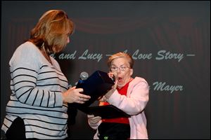Lucy Mayer reacts to being presented with her award from Lisa Comes during the 4th Annual CommUNITY Film Fest at the Ohio Theatre in Toledo. Lucy and her husband Donald won in the category of Celebrating Everyday Lives.
