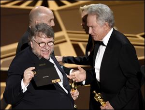 Warren Beatty, right, presents Guillermo del Toro with the award for best picture for 
