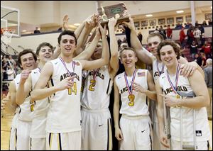 Archbold players hold their trophy aloft Saturday after beating Cardinal Stritch in the Division III boys basketball northwest district final at Central Catholic High School in Toledo. Archbold won, 74-65.