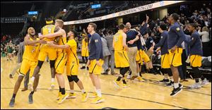 University of Toledo players celebrate after defeating Eastern Michigan 64-63 in a MAC Tournament semifinal at Quicken Loans Arena in Cleveland.