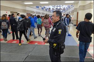Toledo police officer Rick Trevino outside of the cafeteria as one lunch period ends at Bowsher High School.