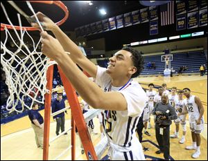 Kyren Bolden of St. John's Jesuit cuts his portion of the net after the Titans defeated Anthony Wayne to a win a district championship at Savage Arena.