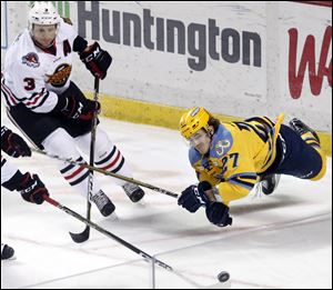 A.J. Jenks of the Toledo Walleye reaches for the puck Zach Miskovic of the Indy Fuel during an ECHL game at the Huntington Center in Toledo Sunday, March 11, 2018.