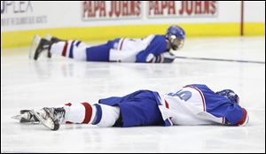 St. Francis de Sales player Matthew Snyder (19) lays on the ice after the Knights lost the state championship game to Cleveland St. Ignatius in double overtime.