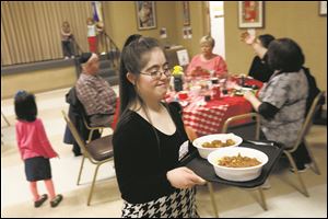 Rachel Rubin, 19, serves up dinner orders at this year's Friendship Circle Cafe Tuesday, February 20, 2018, at Congregation Etz Chayim in Toledo. 
