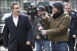 Attorney Michael Cohen, left, talks to CNN freelance producer Wes Bruer as he walks in New York, Wednesday, April 11, 2018. Federal agents who raided the office of President Donald Trump's personal attorney were looking for information about payments to a former Playboy playmate and a porn actress who claim to have had affairs with Trump, two people familiar with the investigation said.