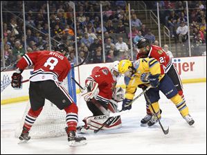 Indy Fuel defenders, including goalie Etienne Marcoux, Chris Rygus, left, and Jaynen Rissling, prevent Toledo forward Tyler Barnes from scoring during their first round ECHL playoff game Sunday at the Huntington Center. The Walleye won, 4-3, to take a 2-0 lead in the series.