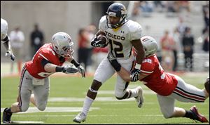 Toledo's Eric Page, center, runs against Ohio State's Tyler Moeller, left, and Storm Klein during a 2011 meeting in Columbus. Ohio State beat Toledo 27-22.