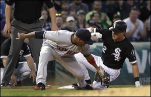 Chicago White Sox's Charlie Tilson, right, slides into third behind Cleveland Indians' Jose Ramirez on an RBI triple.