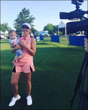 LPGA pro Sydnee Michaels holds her daugther Isla at an event. The LPGA provides daycare for children at each tournament site.