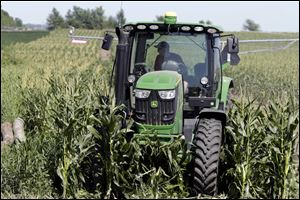 In this July 24, 2018, file photo farmer Tim Novotny, of Wahoo, shreds male corn plants in a field of seed corn, in Wahoo, Neb.